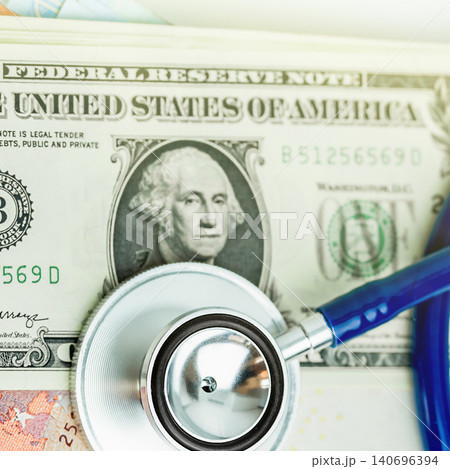 Medical stethoscope lying on a one dollar US bill background Medical stethoscope lying on a one dollar US bill background 140696394