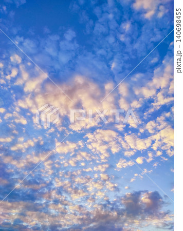 Dramatic clouds background, vertical shot. Bright evening clouds during sunset, beautiful colours in sky Dramatic clouds background, vertical shot. Bright evening clouds during sunset, beautiful colours in sky 140698455