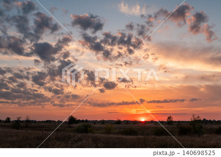 Sunset with beautiful colorful clouds in the sky. Evening in the countryside, bright sky above horizon Sunset with beautiful colorful clouds in the sky. Evening in the countryside, bright sky above horizon 140698525