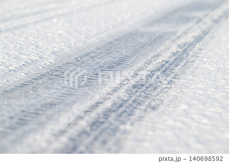Tire tracks on an icy frozen road, close up. Winter season, slippery road, dangerous for driving Tire tracks on an icy frozen road, close up. Winter season, slippery road, dangerous for driving 140698592