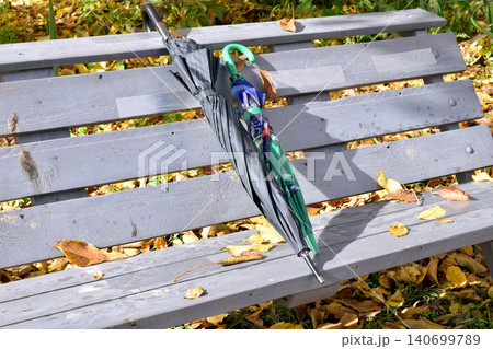 Autumn. Umbrellas are lying on a wooden bench. Autumn. Umbrellas are lying on a wooden bench. 140699789