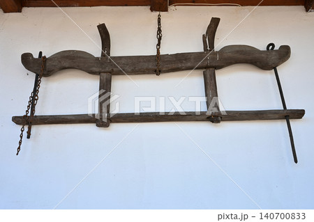 Ancient Wooden Ox Yoke and Farming Tool Hanging on White Wall 140700833