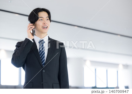 スマートフォンで顧客対応を行う若手ビジネスマン コミュニケーションと営業活動に取り組む若手会社員 スマートフォンで顧客対応を行う若手ビジネスマン コミュニケーションと営業活動に取り組む若手会社員 140700947