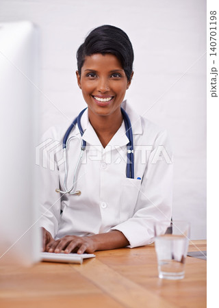 Portrait, doctor and happy woman typing on computer in hospital for healthcare career in India. Face, smile and medical professional on keyboard for wellness and online research at desk in clinic Portrait, doctor and happy woman typing on computer in hospital for healthcare career in India. Face, smile and medical professional on keyboard for wellness and online research at desk in clinic 140701198