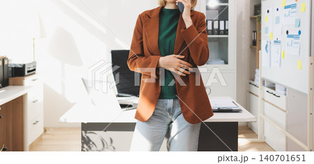 Woman smiling to herself as she works in an office 140701651