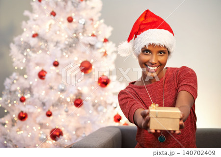 Smile, santa hat and portrait of woman with present at her home for christmas event, party or celebration. Happy, holidays and face of female person with festive xmas tree and gift on sofa at house. Smile, santa hat and portrait of woman with present at her home for christmas event, party or celebration. Happy, holidays and face of female person with festive xmas tree and gift on sofa at house. 140702409
