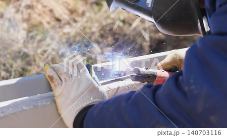 Welder Feeding Filler Rod During Tack Weld Process, Focused Hand Motion And Bright Arc, Tiny Pools Of Molten Metal And Quick Spark Flashes, Industrial Technique For Joining Heavy Sections 140703116