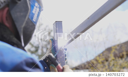 Welder Creating Bright Welding Arc At Joint Outdoors, Intense Blue Light And Molten Pool, Helmet Visor Down, Gloves Gripping Torch, Dramatic Sparks, Safety Oriented Industrial Vibe 140703272