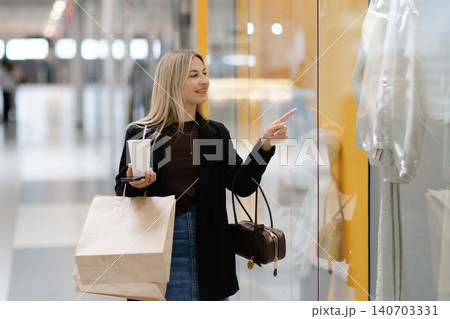 Young woman pointing at shop window while shopping 140703331