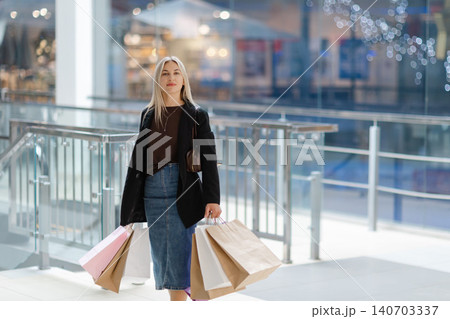Woman enjoying shopping day carrying colorful bags 140703337