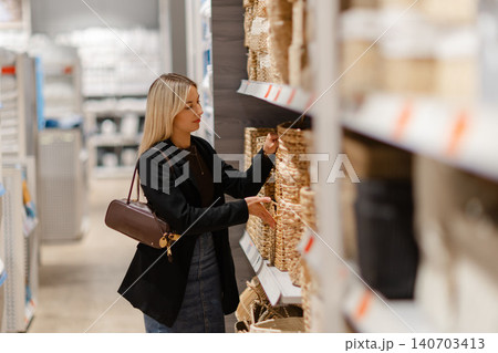 Woman choosing wicker basket for home decor in store Woman choosing wicker basket for home decor in store 140703413