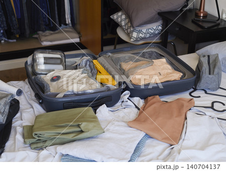 an open suitcase organized with travel clothes 140704137