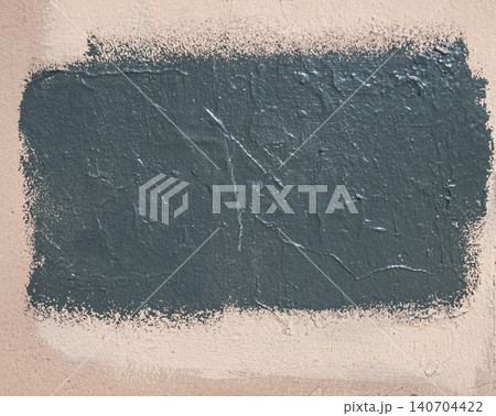 Black paint splash covering a graffiti sign on a textured wall, urban abstract 140704422