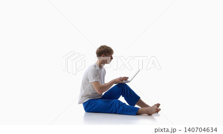 Teen boy sitting with laptop on isolated white background. Teen boy sitting with laptop on isolated white background. 140704634