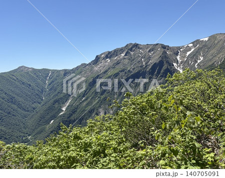 谷川岳の山並みと関越トンネル換気塔が見える新緑の山岳風景 140705091