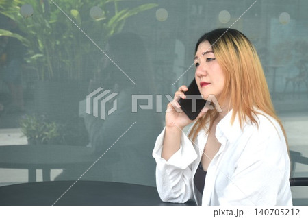 business woman sitting on chair and using mobile phone in community mall garden 140705212