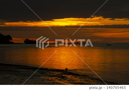 Calm ocean waters reflecting soft golden light beneath a dramatic sky creating a peaceful seascape horizon view 140705463