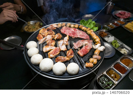 Grilled Meat and Vegetables on Korean BBQ Grill with Smoke and Sides Grilled Meat and Vegetables on Korean BBQ Grill with Smoke and Sides 140706020