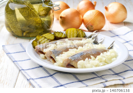 young Dutch herring and onions and pickles , traditional Dutch delicacy on kitchen table. 140706138