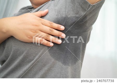 Sweaty underarms, Asian woman with sweat on clothes under armpit. 140707738