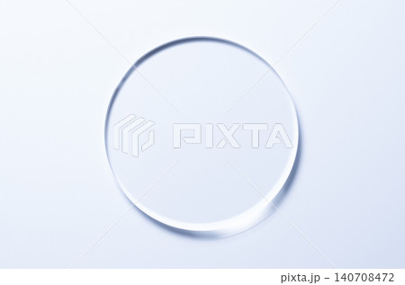 A glass circle on a blue background. A template for placing samples of cosmetics or medical products or food. A glass circle on a blue background. A template for placing samples of cosmetics or medical products or food. 140708472