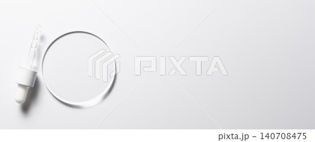 A glass circle on a pink background. A template for placing samples of cosmetics or medical products or food. A glass circle on a pink background. A template for placing samples of cosmetics or medical products or food. 140708475