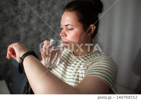 Person glancing at smartwatch briefly then returning to everyday routine. Health data as quiet check not lifeline. Calm tracking without anxiety. Tech supports not controls concept 140708552