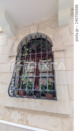 Medieval window  with iron fence and flower pots in a old town 140708986