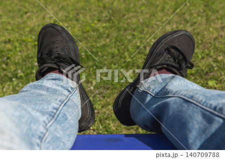 Casual black sneakers and blue jeans, outdoor relax Casual black sneakers and blue jeans, outdoor relax 140709788
