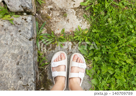 White rubber sandals and bare feet White rubber sandals and bare feet 140709789