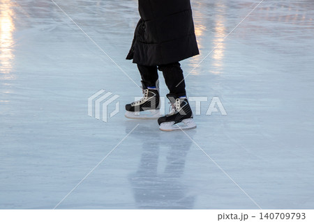 Close-up of a person wearing hockey-style ice skates Close-up of a person wearing hockey-style ice skates 140709793