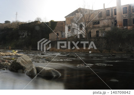 Abandoned industrial factory on a rocky river Abandoned industrial factory on a rocky river 140709842