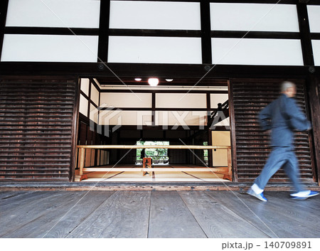 Monk walking through traditional japanese temple architecture 140709891