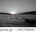 Boat floating at sunset in black and white with red accents 140709895