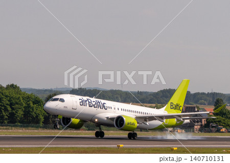 AirBaltic Airbus A220 passenger airplane landing on runway AirBaltic Airbus A220 passenger airplane landing on runway 140710131