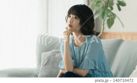 ソファに座って考えごとをする女性 ソファに座って考えごとをする女性 140710472