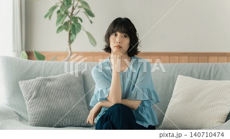 ソファに座って考えごとをする女性 140710474
