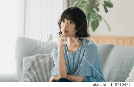 ソファに座って考えごとをする女性 140710475