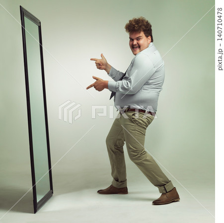 Mirror, portrait and man with smile pointing, double chin and happiness for reflection in studio. Overweight, plus size and male person with obesity, comic and excited to change unhealthy life Mirror, portrait and man with smile pointing, double chin and happiness for reflection in studio. Overweight, plus size and male person with obesity, comic and excited to change unhealthy life 140710478