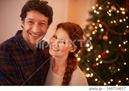 Couple, portrait and Christmas, holiday celebration and festive season of giving for love and commitment. Happiness, hug and support with people at home for tradition, romance and relationship 140710657