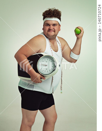 Scale, man and portrait with apple for health, fitness or nutrition isolated on gray studio background mockup. Plus size, body and eating fruit for weight loss diet of male person with tape measure Scale, man and portrait with apple for health, fitness or nutrition isolated on gray studio background mockup. Plus size, body and eating fruit for weight loss diet of male person with tape measure 140710724