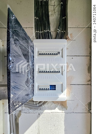 Electrical fuse box with circuit breakers mounted on a concrete wall during renovation. Electrical fuse box with circuit breakers mounted on a concrete wall during renovation. 140711064