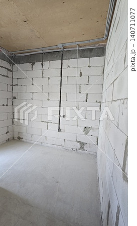 Empty room with aerated concrete walls and electrical wiring during residential construction. Empty room with aerated concrete walls and electrical wiring during residential construction. 140711077