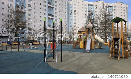 Empty modern playground for caucasian boys and girls sits in a residential urban courtyard area. Empty modern playground for caucasian boys and girls sits in a residential urban courtyard area. 140711080