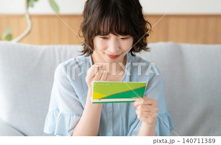 通帳を見て喜ぶ女性 140711389