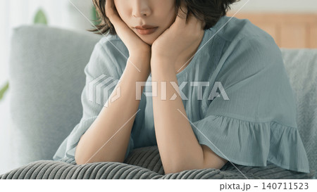 ソファに座って考えごとをする女性 ソファに座って考えごとをする女性 140711523
