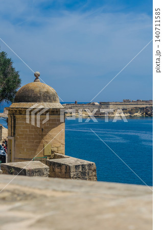 Historic limestone watchtower turret on Valletta fortification wall overlooking blue Mediterranean Sea and Fort in sunny Malta Historic limestone watchtower turret on Valletta fortification wall overlooking blue Mediterranean Sea and Fort in sunny Malta 140711585
