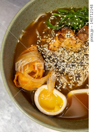 Noodle bowl. Japanese cuisine. Meat with half egg kimchi green seaweed salad served in spicy soy sauce delicious ramen with sesame. Noodle bowl. Japanese cuisine. Meat with half egg kimchi green seaweed salad served in spicy soy sauce delicious ramen with sesame. 140712148
