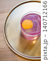 Pink cocktail. Cold beverage. Bright color alcohol liquid with large ice cube decorative citrus zest garnish served on metal tray. 140712166