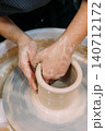 Artistic occupation. Creative earthenware. Unrecognizable professional woman hands master working with clay pot in artisan workplace. 140712172